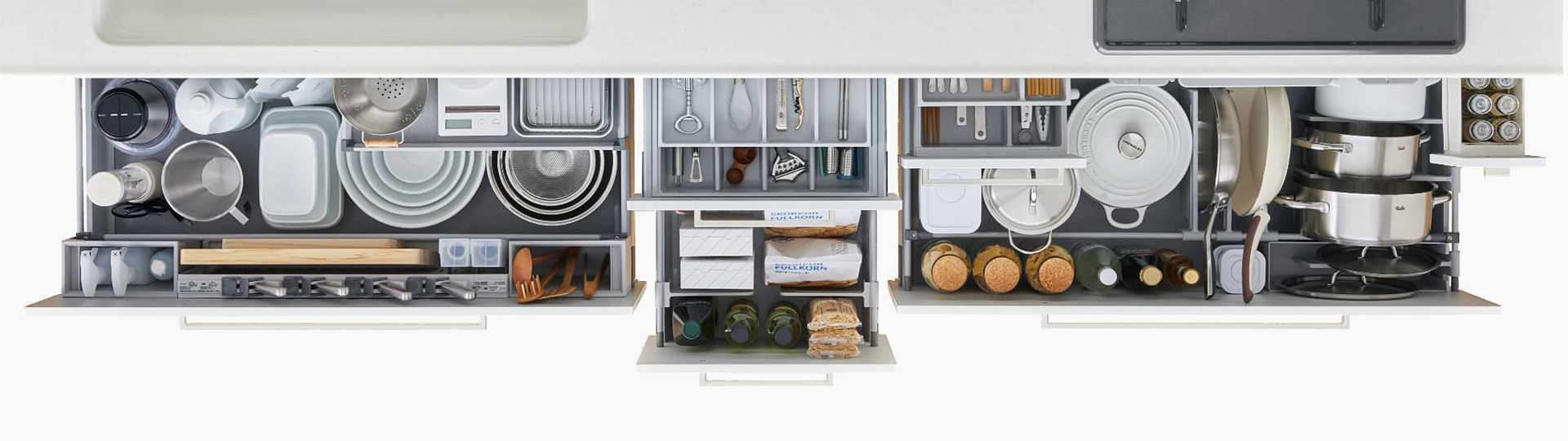 [ 画像 ] 欲しいものがすぐ見つけられるオーバービュー収納。どこに何があるかがすぐにわかることが大事と考え、引出し間口をワイドにして、収納物全体がひと目で見渡せる設計です。シンク下もコンロ下も、収納物にあわせた工夫を盛り込み、より収納しやすく、見つけやすく、取り出しやすくを追求しています。