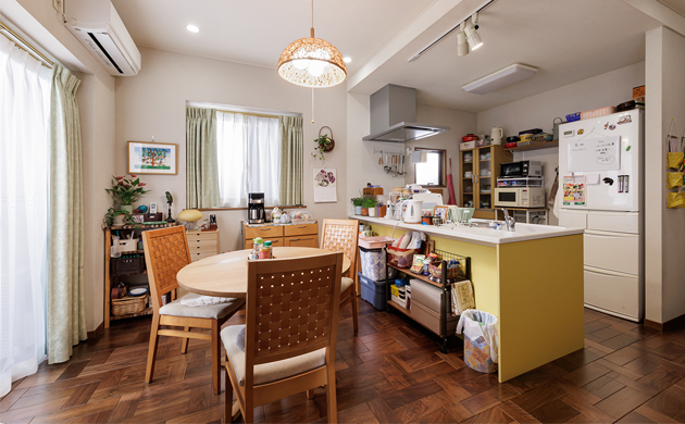 ドラマ『時すでにおスシ!?』に採用されたフラットオープン型の黄色いキッチンがあるLDK。